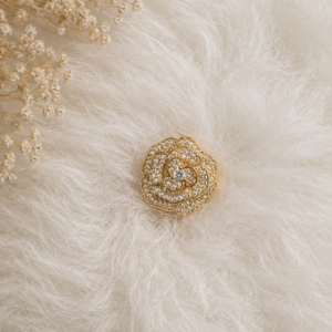 Charmoso e sofisticado, o Broche em Forma de Rosa Cristal Dourado combina brilho e elegância em um design moderno e delicado. Com destaque nos cravejados lapidados, a peça transmite personalidade e um toque fashion ao visual.